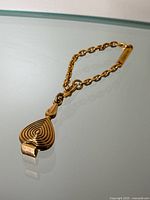 Charm close-up showing top portion with attachment ring and chain.