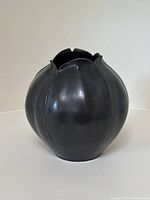 Front view of vase showing lobed cylindrical shape and bronze-like finish