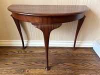 Front view of half-moon top and three cabriole legs