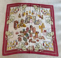 Full view of scarf laid flat showing border and full perfume bottle design.