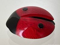 Angled top view showing red textured wings and black spots