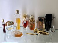 Full lot of perfume bottles and accessories arranged on glass shelf