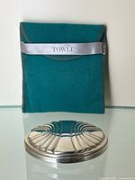 Front view of sterling silver compact mirror and green Towle pouch.