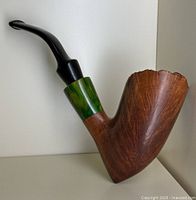 Side angle view of vintage wooden pipe showing the wood bowl, green bakelite band, and black curved mouthpiece