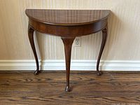 Front view showing half-moon top and cabriole legs