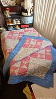 Quilt laid out on a bed showing the patchwork pattern and colors.