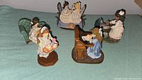 Group photo showing all five Sandra Kuck collectible figurines on a green cloth.