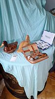 Full view of two duck figurines, vanity travel set, and child's fork and spoon set on blue drape