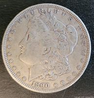 Obverse of 1890 Morgan Silver Dollar, showing Lady Liberty profile, date, and inscription details.