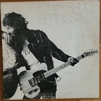 Front cover of Bruce Springsteen's "Born to Run" 1975 vinyl album featuring a black and white photo of Bruce playing guitar.