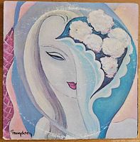 Front cover of Derek and the Dominos 1970 double album showing abstract artwork with a face and flowers, signed Fryndsen.