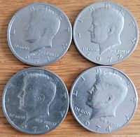 Obverse side of the four Kennedy half dollar coins dated 1971, 1972, 1973, and 1974 showing the profile of President John F. Kennedy.