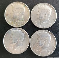 Front (obverse) sides of four Kennedy half dollars dated 1966, 1967, 1968, and 1969 showing John F. Kennedy's profile. Some coins have visible oxidation or discoloration.