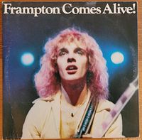 Front cover of the album showing Peter Frampton with curly hair, illuminated by stage lights, holding a guitar.
