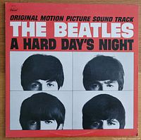 Front cover of The Beatles 'A Hard Day's Night' album showing red background with black and white images of the band members' faces.