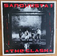 Front record album cover for The Clash's 'Sandinista!' showing band members in black and white with red text.