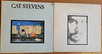 Photo showing the front covers of two Cat Stevens albums: "Teaser and the Firecat" with its illustrated cover, and "Foreigner" featuring a photographic image of Cat Stevens' face.