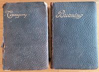 Two leather bound books with textured dark blue covers embossed with 'Tennyson' and 'Browning' on front. The Tennyson book shows damage and wear on the cover edges.