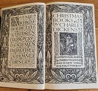 Open book displaying decorative title page with ornate floral border and text 'Christmas Books by Charles Dickens' published by JM Dent & Sons and E.P. Dutton & Co in 1913.