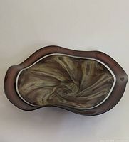 Top view of the blown glass bowl showing the swirling aubergine interior and wavy rim
