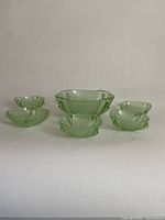 Full set of one large fruit bowl and six matching smaller bowls arranged on white background, showing size and style relation