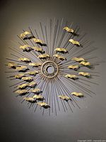 Full frontal view of the entire sculpture on wall, showing radial burst and bird motifs.