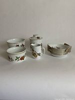 Full view of all items in lot showing large ramekin, small pitcher, small canister, small bowl, and 6 egg dishes