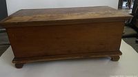 Front view of the wooden blanket box showing the aged rustic finish and rectangular shape with a flat top lid.