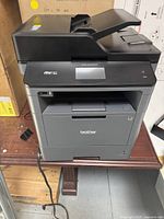 Front view of entire printer showing paper tray and touchscreen