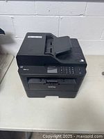 Front view of the Brother MFC 2730DW multifunction printer showing the control panel with LCD, keypad, and paper output tray.