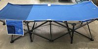 Blue Hidden Wild XL portable folding camp cot with black metal frame and side storage pocket