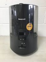 Front view of Honeywell humidifier showing brand name, control panel with digital display, and sticker indicating quick fill time of 5 minutes.