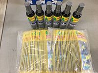 Six bottles of Little Trees Odor Eliminator Air Wash spray with multiple packs of Little Trees hanging air fresheners in the background, visible on a table.