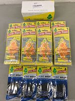 Display of multiple Little Trees air fresheners including sliced orange slice scent and vent wrap New Car scent packages.