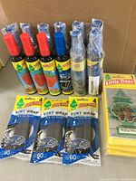 Overview image showing all items including 11 spray bottles with strawberry, new car and blue z scents, 3 packs of vent wraps, and 4 hanging pine fresheners.