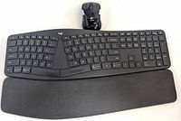 Logitech Ergo K860 wireless split ergonomic keyboard in dark gray with attached wrist rest and USB receiver placed on top