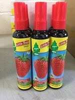 Three bottles of Little Trees Strawberry scent car air freshener spray with red caps and strawberry labels.