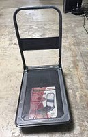 Foldable platform truck push dolly in open position showing platform, handle, and label.