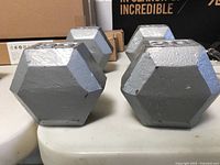 Pair of gray hex dumbbells with embossed '20' weight markings shown from front.