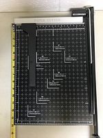Top view of paper cutter with measurement grid and paper size templates.