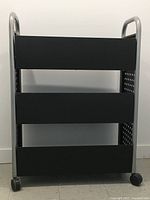 Front view of the steel book cart showing three slanted shelves and tubular steel frame with black finish