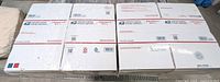 Stack of 50 new USPS Priority Mail large mailing boxes, sealed and branded with USPS logos and Priority Mail markings visible.