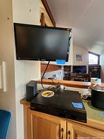 Sony 2-in-1 VCR DVD combo player placed below the TV on a wooden surface showing the front face and controls.