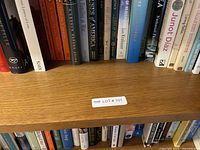 Close-up view of a portion of the bookshelf with book spines visible, indicating presence of many hardcover and paperback books.