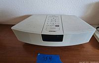 Front view of the Bose Wave Radio showing the full unit with control buttons on top and speaker grille front.