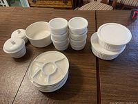 All items shown including crocks with lids, ramekins with lids, bowls, and divided plates.