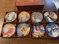 Photo of full set of 8 collector plates featuring various Cinderella scenes in original 8 drawer cardboard storage case