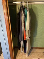 Photo shows multiple women's clothing items hanging on a rack in various colors including black, beige, green, orange, cream, size small.