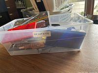 Bin filled with various household hand tools showing different screwdriver types, small utility knife, and multifunction tool