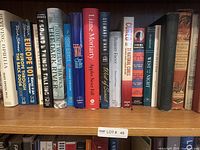 Shelf showing a row of assorted books in very good condition with various bindings and titles visible.